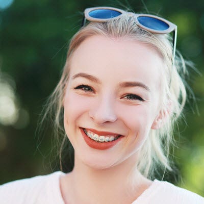 A female smiling with braces on teeth